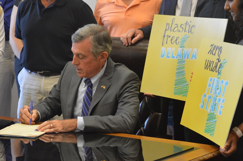 Gov. John Carney signs new law that bans the usage of polystyrene foam, as well as law that allows a special license plate for Plastic Free Delaware at Legislative Hall Tuesday.