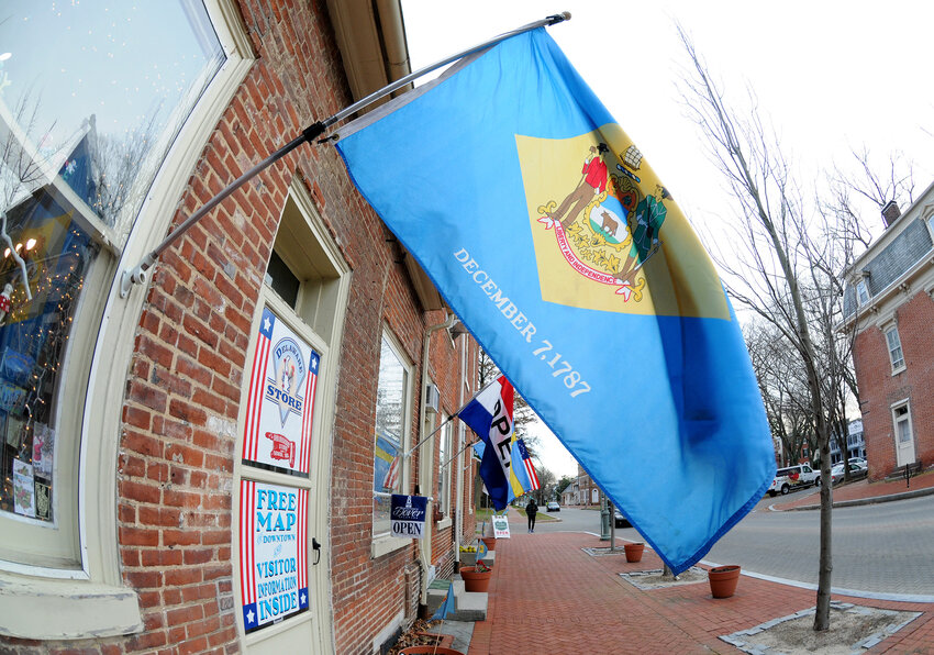DelawareDay1.The Delaware State Flag waves in the wind in front of the Delaware Store on State Street in Dover. Delaware State News/Marc Clery