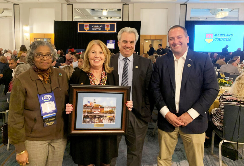 Worcester County Commissioners congratulate Sen. Mary Beth Carozza upon receiving this year&rsquo;s MACo Legislative Recognition Award. Pictured with her from left are Worcester County Commissioner Diana Purnell (District 2), President Chip Berino (District 5) and Commissioners Eric Fiori (District 4). Sen. Carozza holds a framed view of Annapolis from the water.