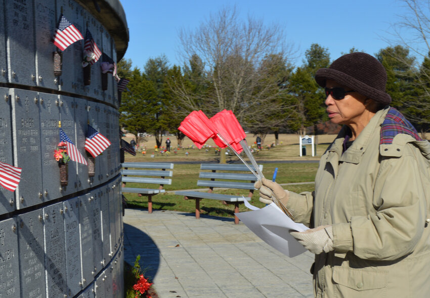 Margaret Hopkins, a member of American Legion Post 28's Auxiliary, scans a columbarium section to place red markers for wreath locations Saturday in Millsboro.