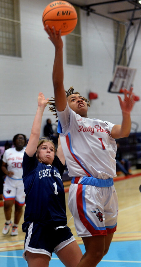 The Hornets' Marshay Brown scores on a layup ahead of Lilyana Zorn of Sussex Academy in the first half Tuesday night.  SPECIAL TO THE DAILY STATE NEWS/GARY EMEIGH