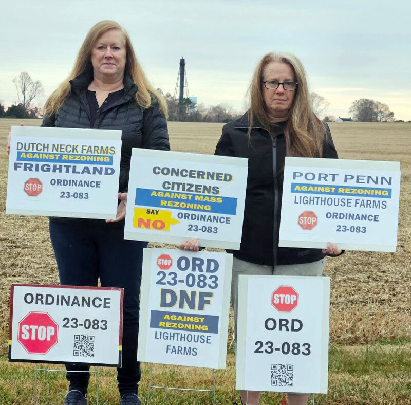 Dutch Neck Farms residents Debbie Pilli (left) and Donna Wood (right) stand outside of the Lighthouse Farms parcel with picket signs opposing New Castle County&rsquo;s mass rezoning ordinance. These pickets and similar ones were on display at the county&rsquo;s planning board meeting Dec. 12.