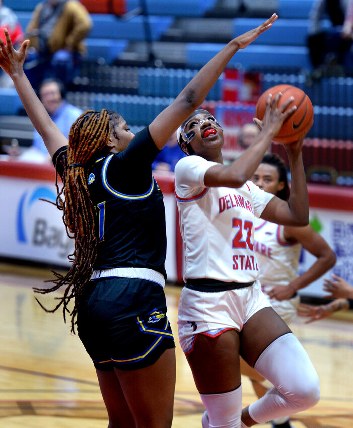 Tyshonne Tollie of Delaware State takes a pass close under the basket and goes up for a shot with Delaware&rsquo;s  Ande&rsquo;a Cherisier trying to block. SPECIAL TO THE DAILY STATE NEWS/GARY EMEIGH