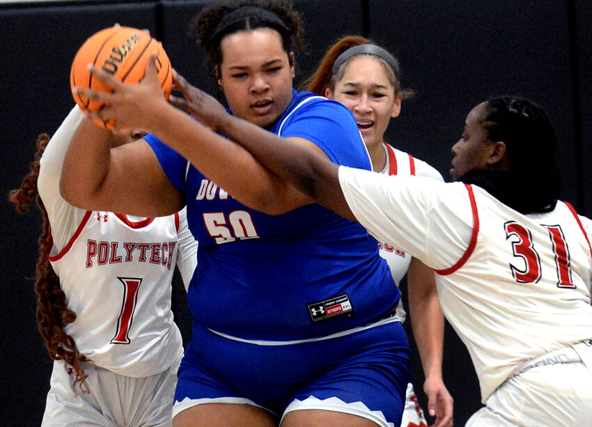 Kaitlyn Hill of Dover pulls down a rebound in front of Polytech&rsquo;s Jasryn Scott-Cottman (1) and Marie Cadet in Thursday&rsquo;s game.  SPECIAL TO THE DAILY STATE NEWS/GARY EMEIGH