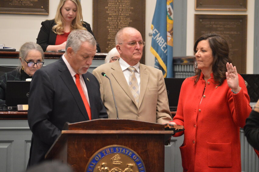 Rep. Tim Dukes, R-Laurel, (left) delivers the oath of office to newly elected Rep. Valerie Jones Giltner, R-Georgetown, on Tuesday alongside her husband, John.