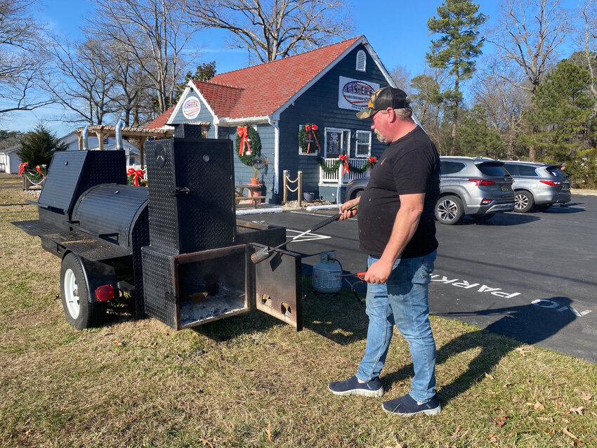 Sean Lasher  of Lasher&rsquo;s BBQ in Long Neck shows the daily ritual of lighting his smoker in front of the restaurant. Mr. Lasher said this smoker was his first purchase after retiring from a career working on the water in the Gulf of Mexico back in the late 2000s.