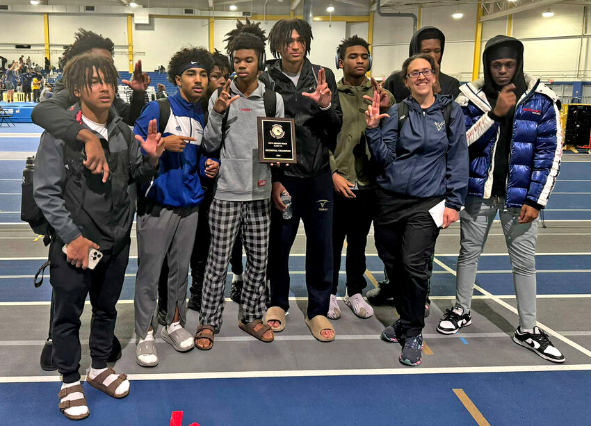 Cambridge-South Dorchester High School track and field Head Coach Stacey Brown celebrated with athletes after the boys' team won the Region 1A East championship on Friday.