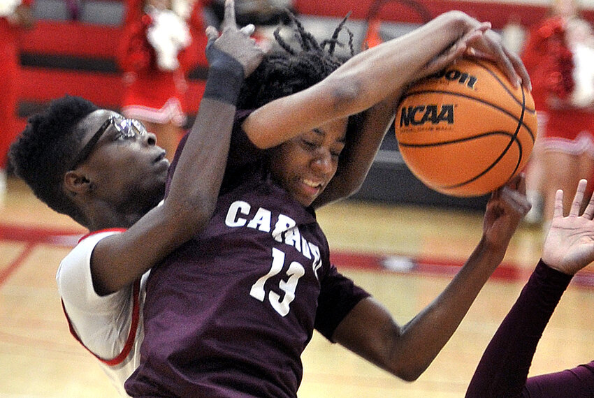 Kai Burnette of Smyrna and Caravel&rsquo;s Cherish Bryant battle for a rebound under the basket in the first quarter Tuesday night.  SPECIAL TO THE DAILY STATE NEWS/GARY EMEIGH
