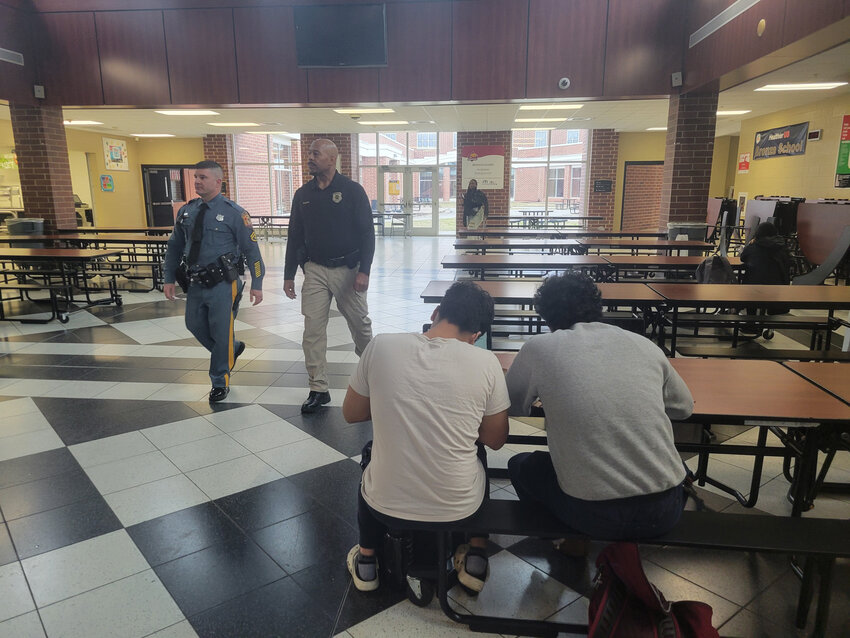 Delaware State Police Master Cpl. Tony Torres, left, walks through Middletown's Appoquinimink High School with constable Doug Dolphin on Wednesday.
