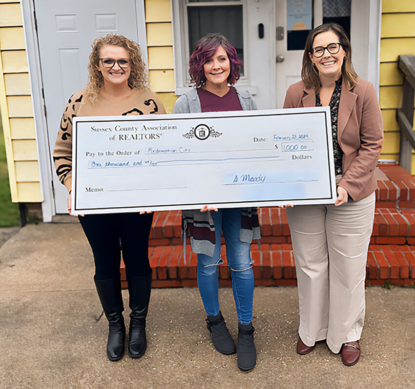 Sussex County Association of REALTORS Association Executive Stephanie Moody (below right) delivers a $1,000 check to Redemption City, a 501C3 organization in Seaford founded by Nikki Gonzalez (below center) that seeks to help homeless individuals find shelter and to provide them with comprehensive and holistic care. The Sussex County Association of REALTORS 2024 Good Neighbor Award Winner Renee Parker (below left) was awarded a check for $1,000 to be presented to the non-profit of her choice.