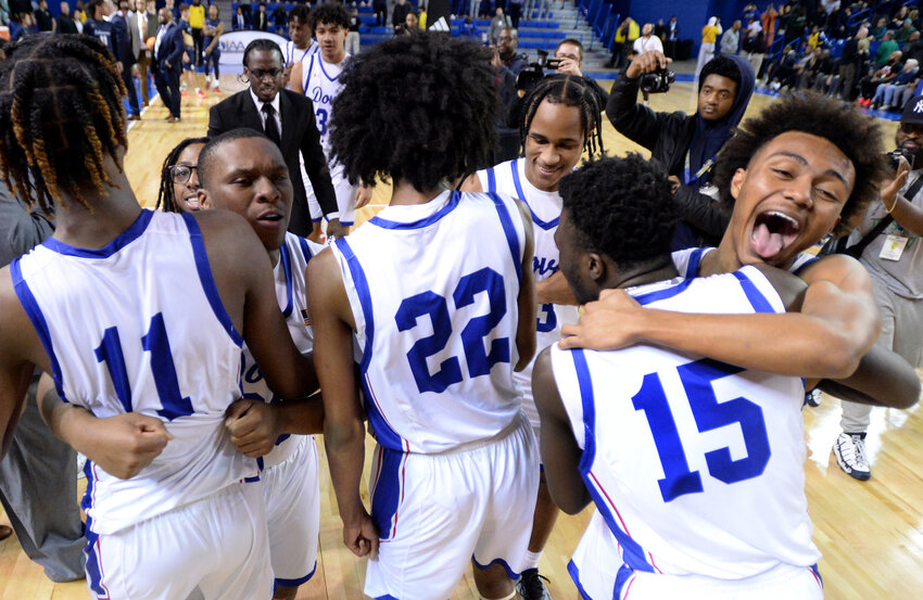 Dover High School's basketball team celebrate after winning the program's first state boys basketball championship.