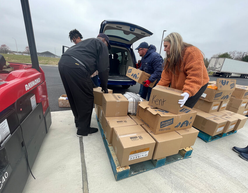 Perdue associates Kris Ricks and Holly Porter load boxes of Perdue chicken and meal boxes to be distributed to food insecure children and families ahead of the Easter holiday.