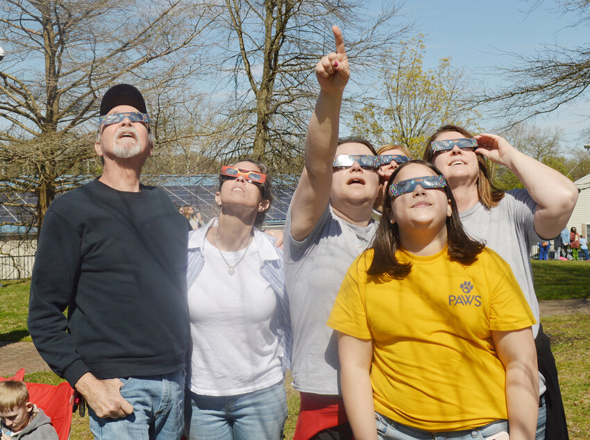 Laurel Public Library staff and volunteers view the solar eclipse Monday from Market Street Park. From left, Charles Scott, Laina Betts Dunn, Stacy Lane (pointing), Karen Scott (in back), Annette Lane and Library Director Gail Bruce.
