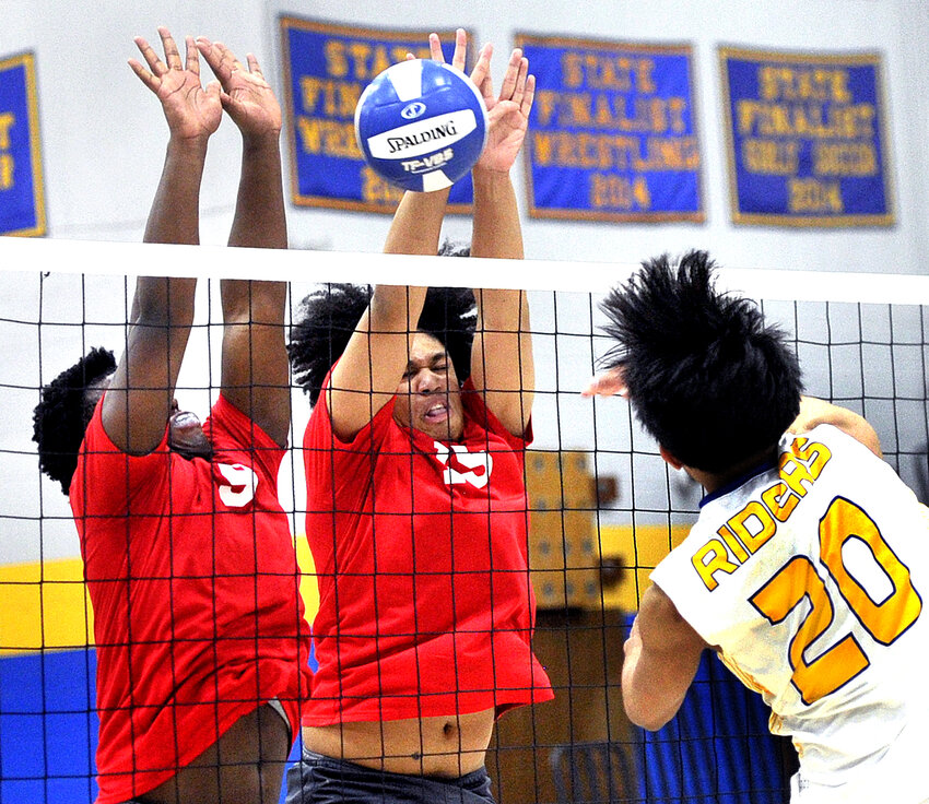 Jaydin Price (left) and Daniel Cruz of Smyrna trying to block spike by Caesar Rodney&rsquo;s Xylord Martin.  SPECIAL TO THE DAILY STATE NEWS/GARYE EMEIGH