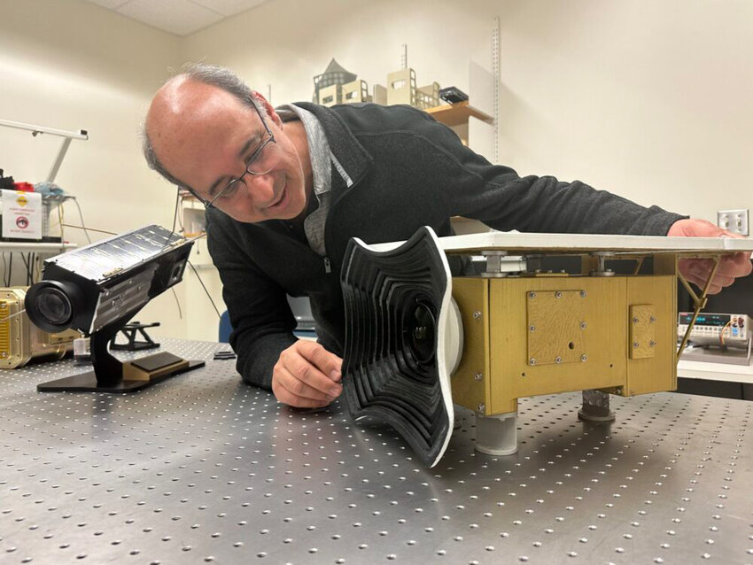 University of Maryland, Baltimore County professor Vanderlei Martins examines a replica of HARP2, an instrument on the Plankton, Aerosol, Cloud, ocean Ecosystem satellite that will help identify particles in Earth&rsquo;s atmosphere.