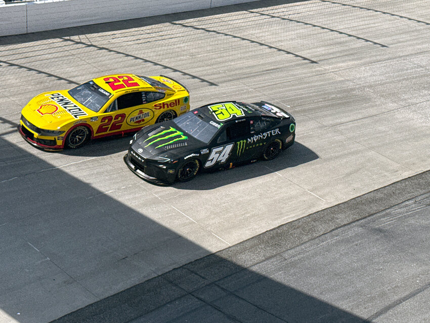 Joey Logano (No. 22) and Ty Gibbs (No. 54) speed through turn two neck and neck.