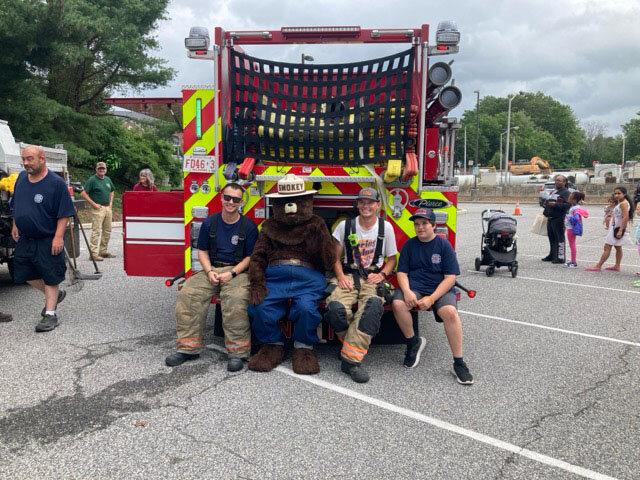 Smokey Bear takes a moment to chat with some of his favorite people &mdash; Dover volunteer firefighters &mdash; during his 80th-birthday celebration at the Dover Public Library on Friday. DAILY STATE NEWS/MIKE FINNEY