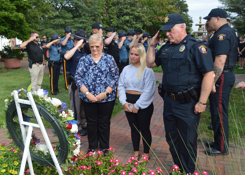 Local and state law enforcement salute Sunday during the annual wreath-laying ceremony for fallen Georgetown Police Patrolman Chad Spicer, who died in the line of duty on Sept. 1, 2009. In front of the memorial wreath are Patrolman Spicer's mother, Ruth Ann Spicer, his daughter, Aubrey Spicer, and Georgetown Police Chief Ralph &quot;Rusty&quot; Holm.