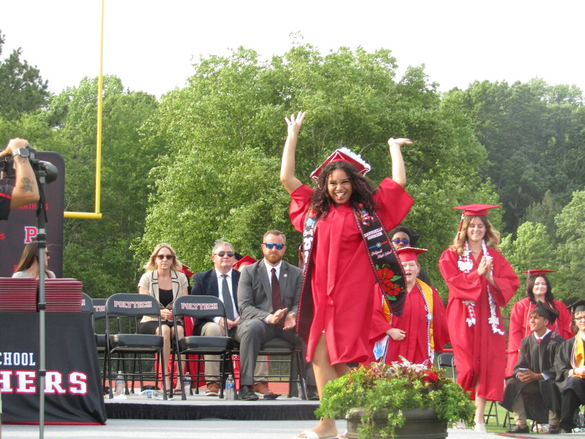A Polytech High School graduate lifts her hands in joy, as she walks to get her diploma Saturday, June 6.