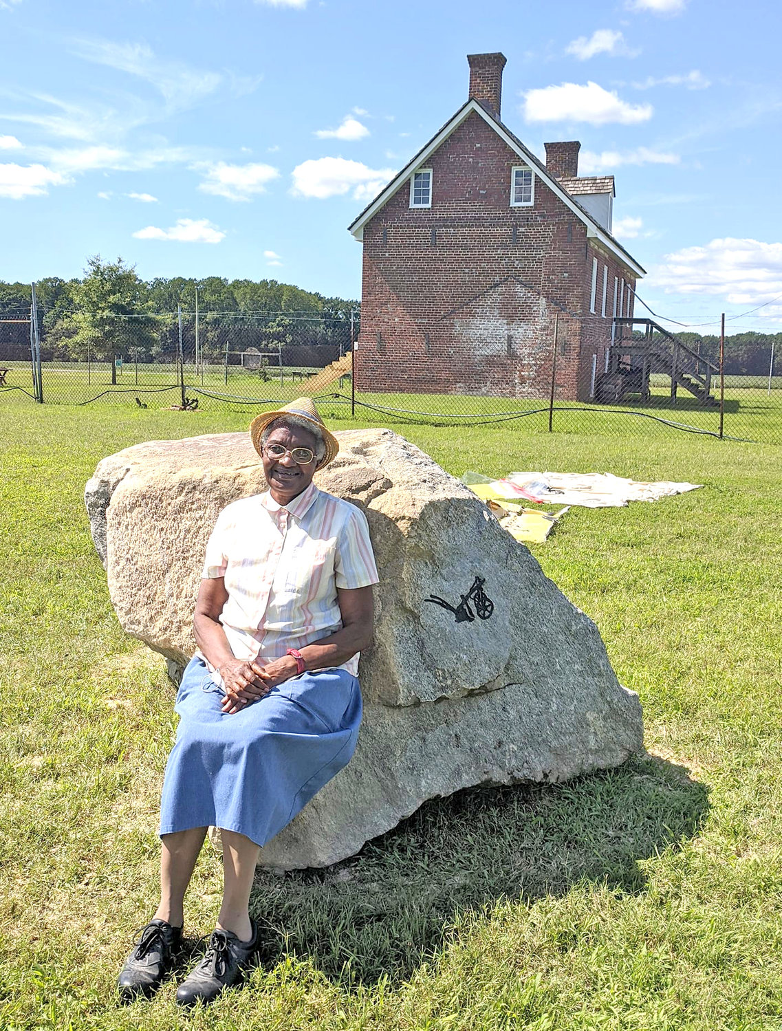 Shirley Jackson is seen seated on a commemorative stone on the Handsell property, near where she lived as a child.
