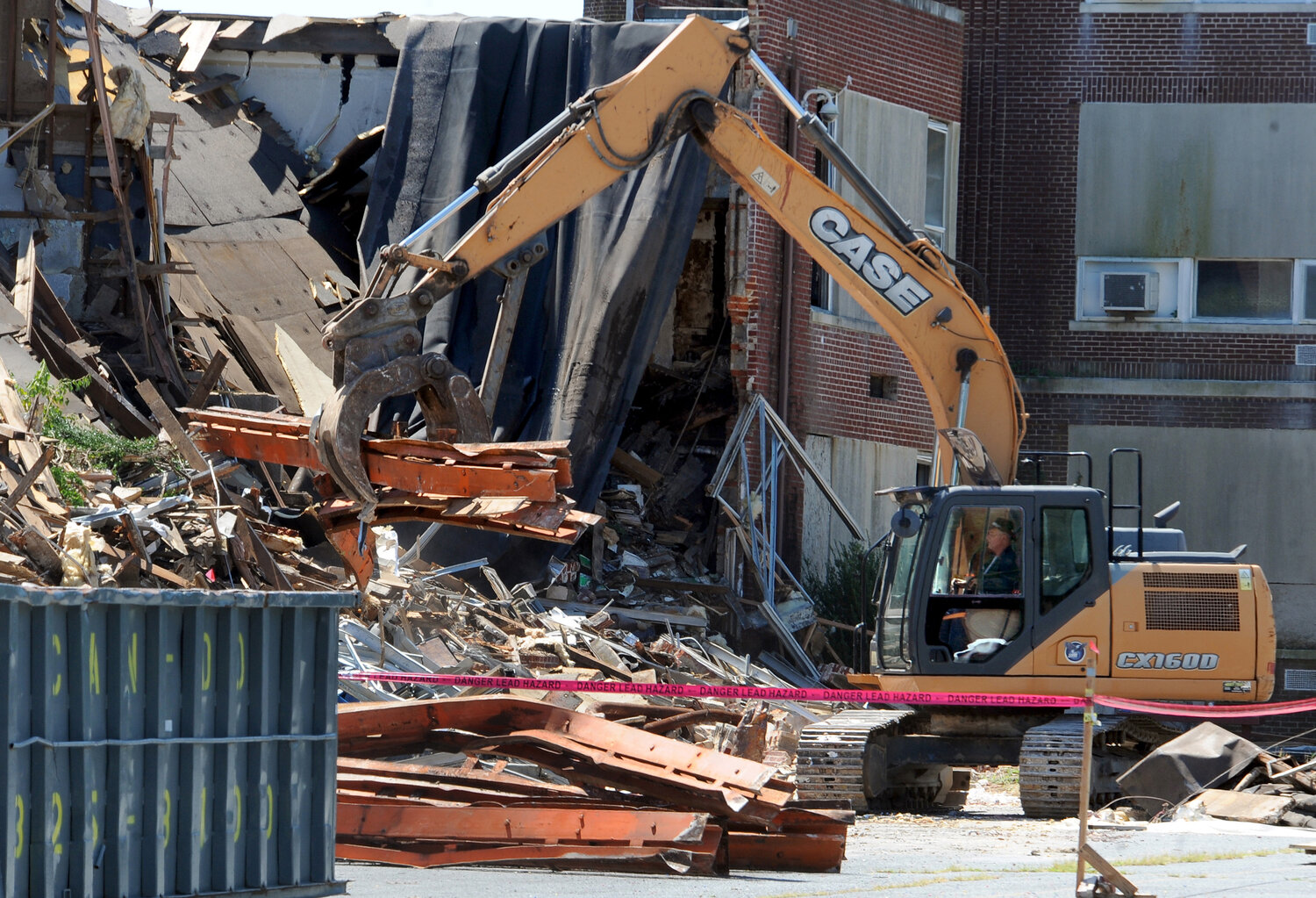 Demolition equipment operator pulling out heavy steel girders from the old Milford Middle School Wednesday.