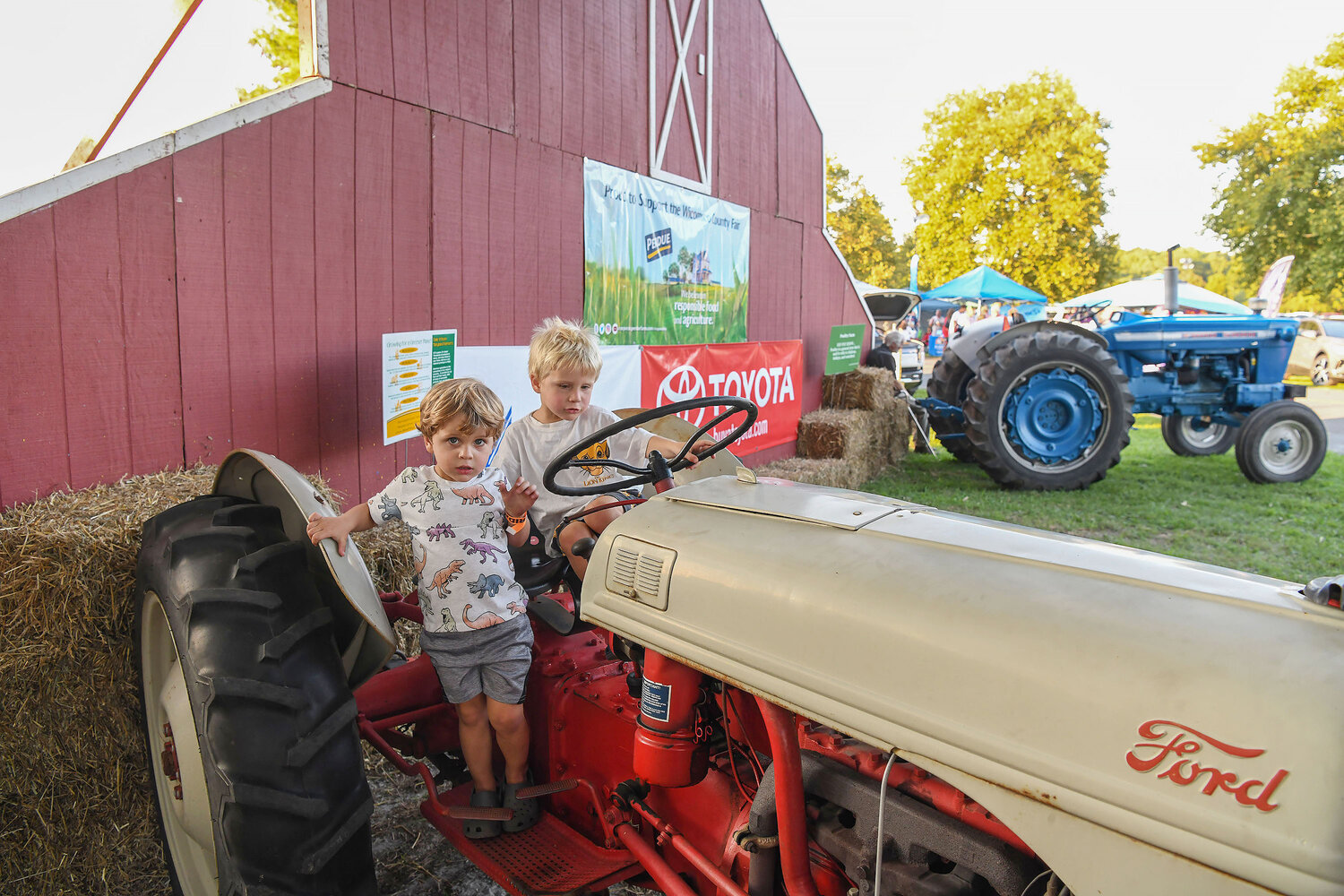 Dawson Cronshaw, 2, gets off a tractor as his brother, Daxton Cronshaw, 5, steers it during the annual Wicomico County Fair, held over the weekend at WinterPlace Park in Salisbury.