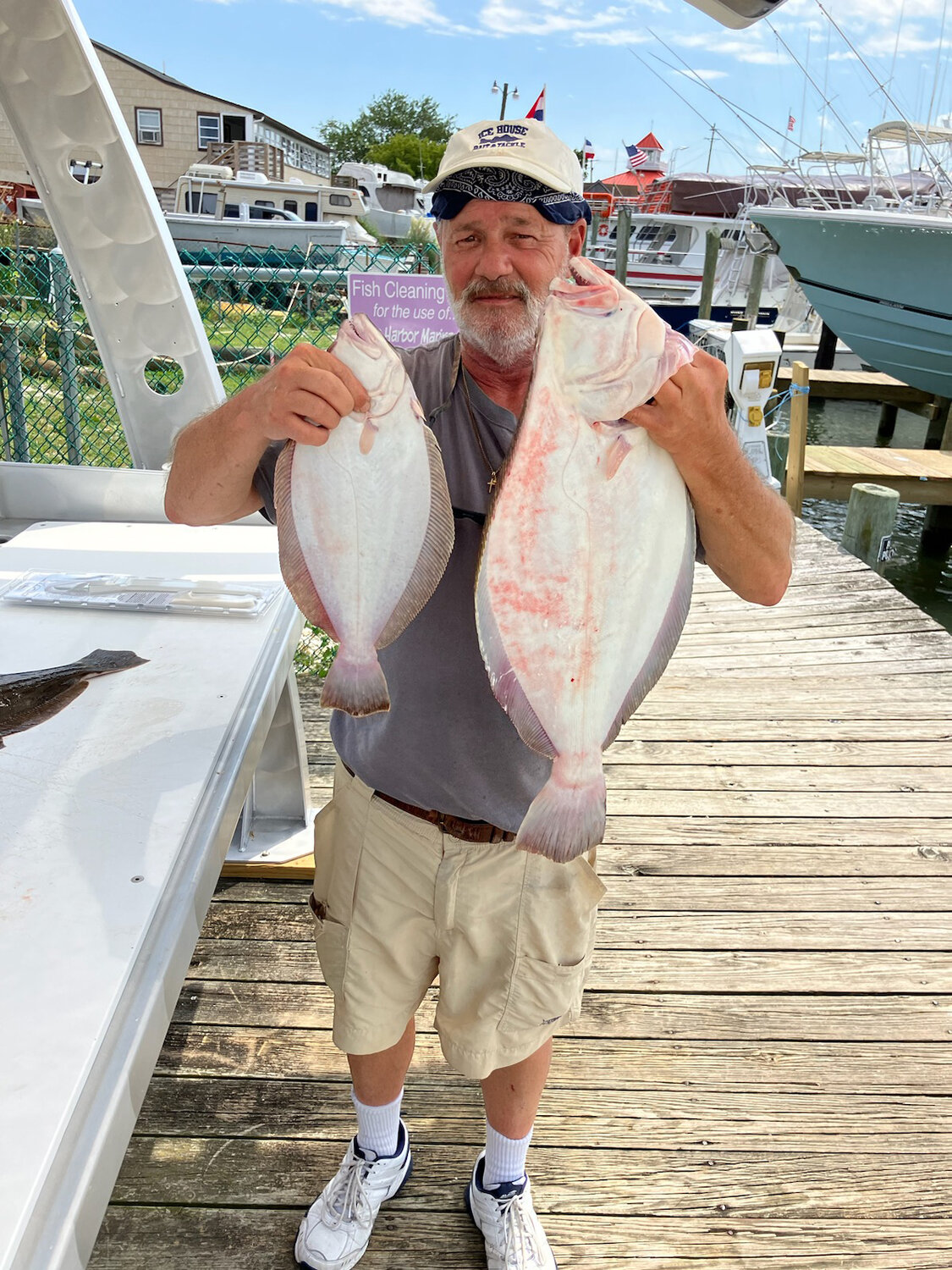Captain Les Clemmer, owner of Icehouse Bait and Tackle, holds two flounder he caught the other day.