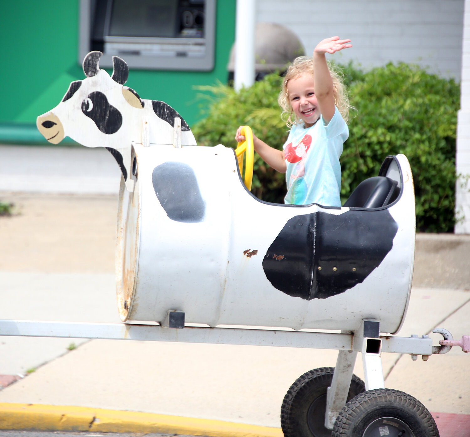 Penelope Dukes, 4, of Felton waves to her family while riding in one of the farm animal cars of a train Saturday at Harrington Heritage Day.