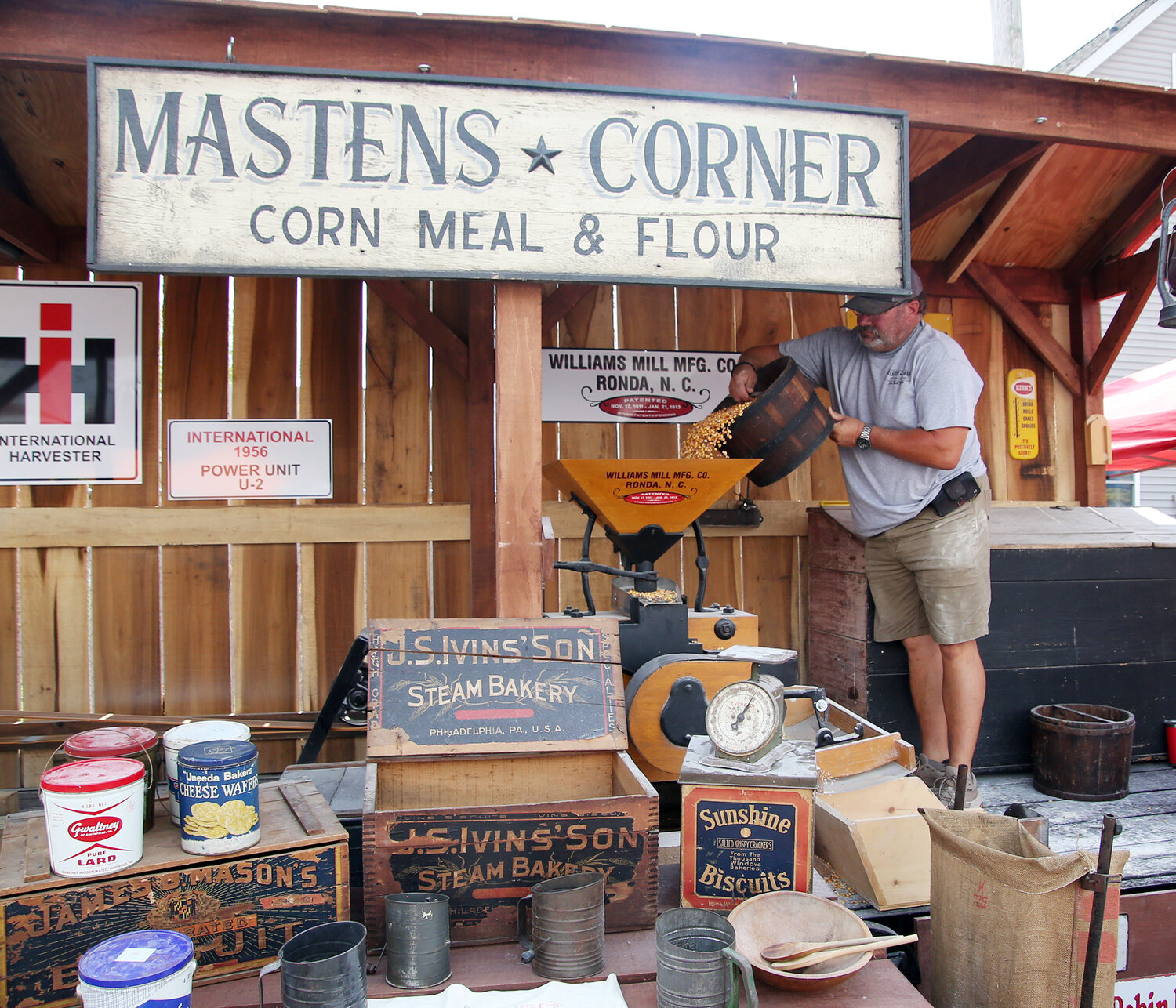 Bruce Betts of Felton loads corn into a 1911 gristmill Saturday at Harrington Heritage Day. The antique machinery has two screens, separating corn meal and grits.