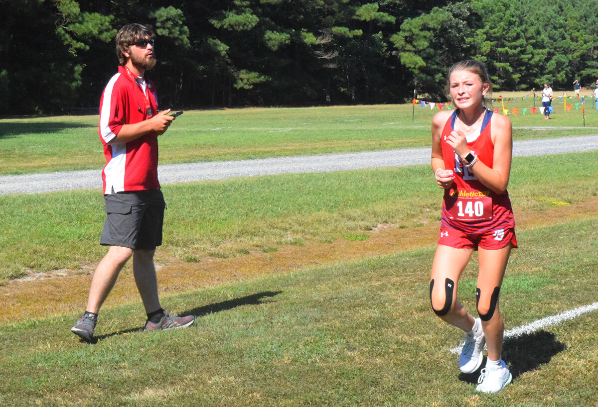 Cross country isn't for the faint of heart. North Dorchester's fastest girl was freshman Adison Thomas, who felt the pain of her efforts with about half a mile to go. She was being encouraged by Eagles' Head Coach Jeffrey Condon.