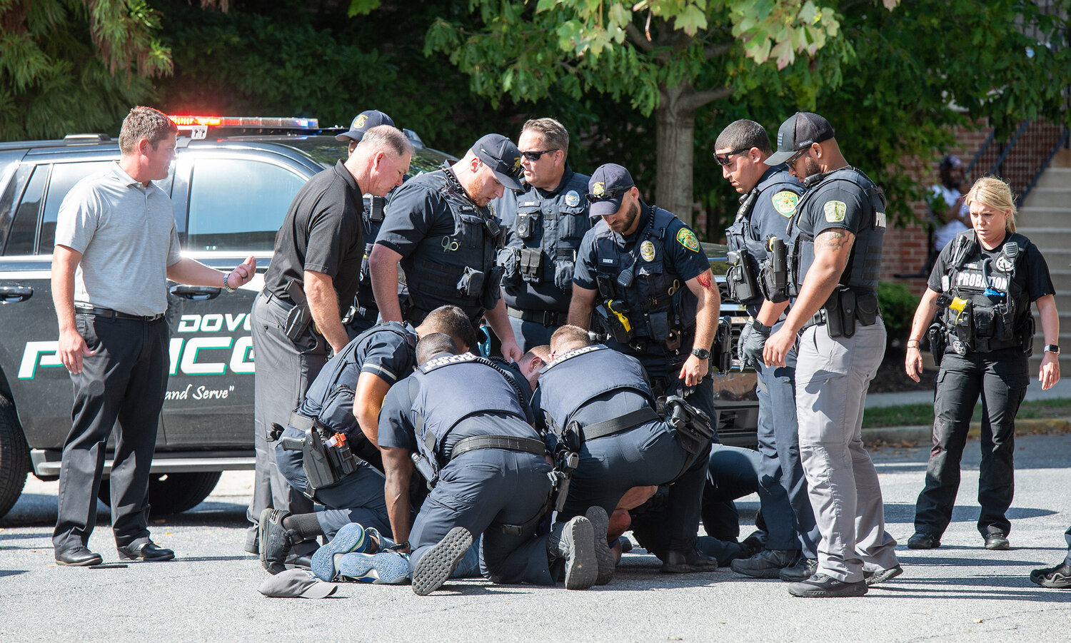 Dover Police officers handcuff a wanted man while being arrested on South Bradford Street in Dover on Monday.