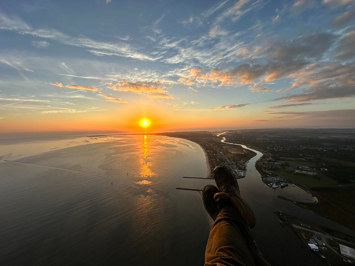 Ryan Peters paraglides over the Roosevelt Inlet at sunrise.