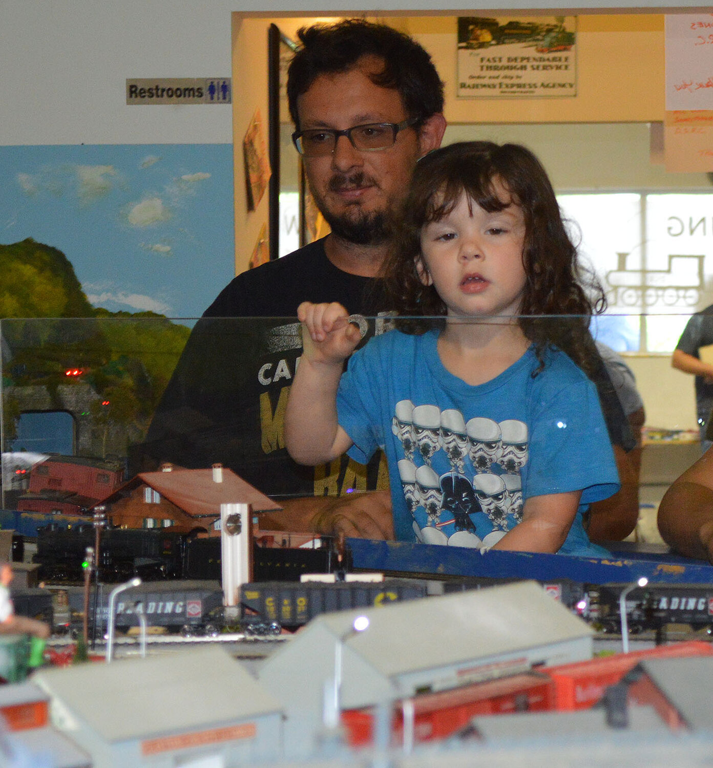 Aria Pagotta peers over the glass as she and her father, Michael Pagotta, view one of the Delaware SeaSide Railroad Club layouts.