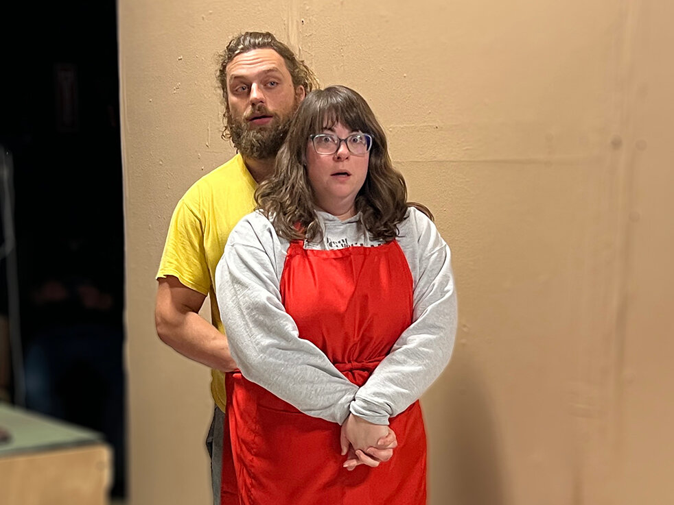 Ben and Sue (Killian McMurphy and Rebekah Lee) shuffle offstage wrapped in a shared apron.