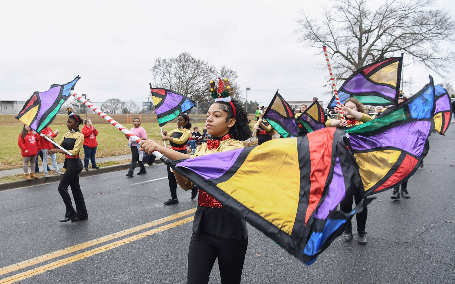Mcikensi Duah with Wicomico Middle School Band twirls a flag with the rest of the band during the parade.