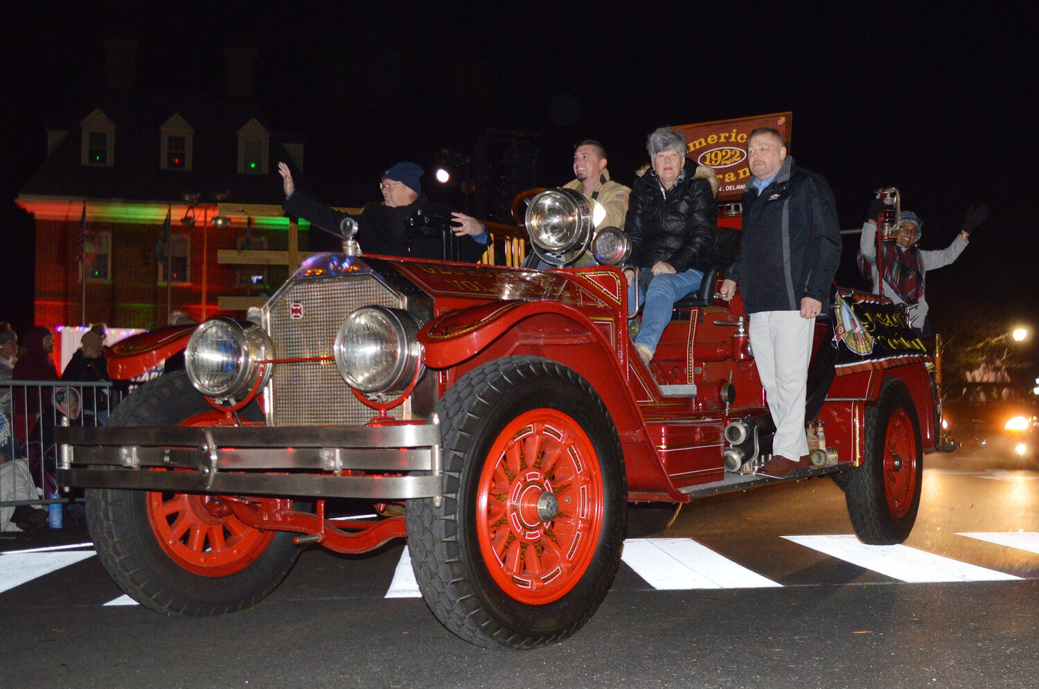 Members of the Georgetown Fire Co. ride a 1922 American LaFrance firetruck in the Georgetown Christmas Parade on Thursday.