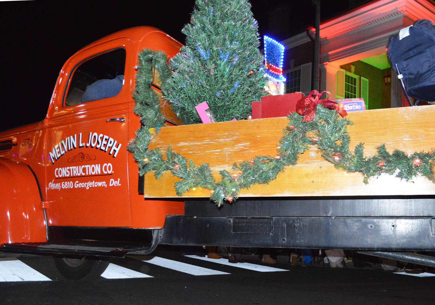 The Melvin L. Joseph Construction Co. entry wheels into The Circle during the Georgetown Christmas Parade on Thursday.