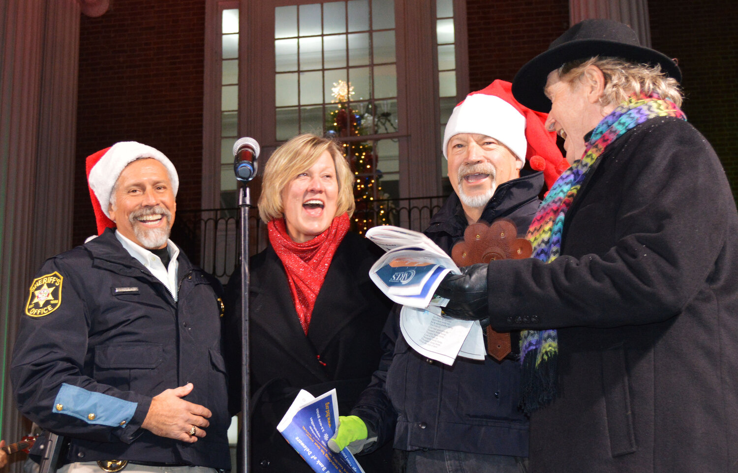 In a festive mood, from left, Sussex County Deputy Sheriff Steve Smyk, Lori Lee, Sheriff Robert Lee and Ed Shockly team up on a holiday favorite during Caroling on The Circle on Thursday.