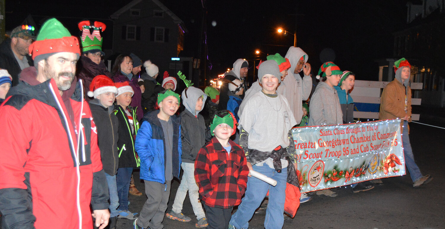 Members of Georgetown Boy Scout Troop 95 and Cub Scout Pack 95 head toward the Circle in the Georgetown Christmas Parade. The scouts provided an escort for the float sleigh carrying Santa Claus.