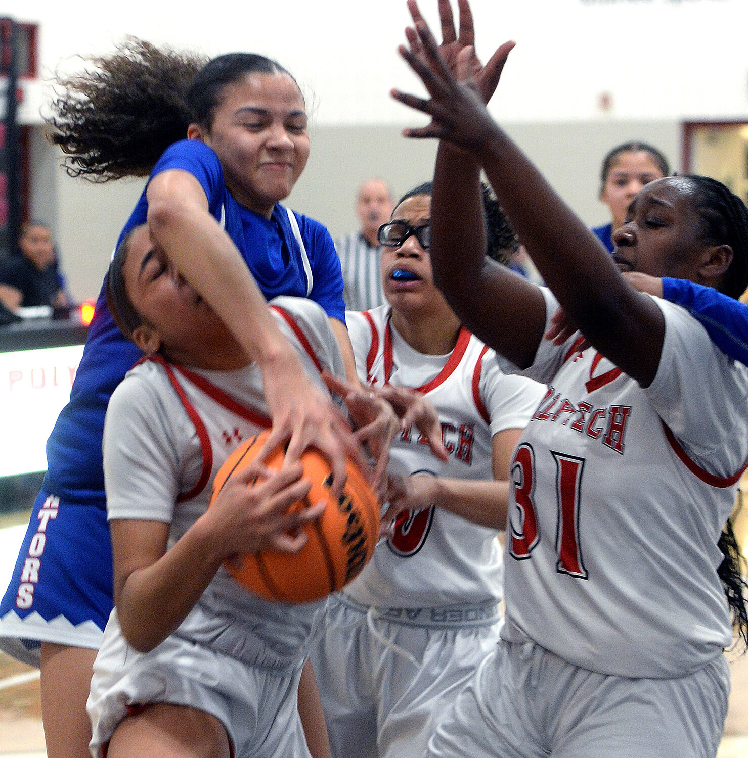 De’Janae Gibson of Polytech comes down with a defensive rebound as Dover’s Malya Milstead reaches in during the second quarter.  SPECIAL TO THE DAILY STATE NEWS/GARY EMEIGH