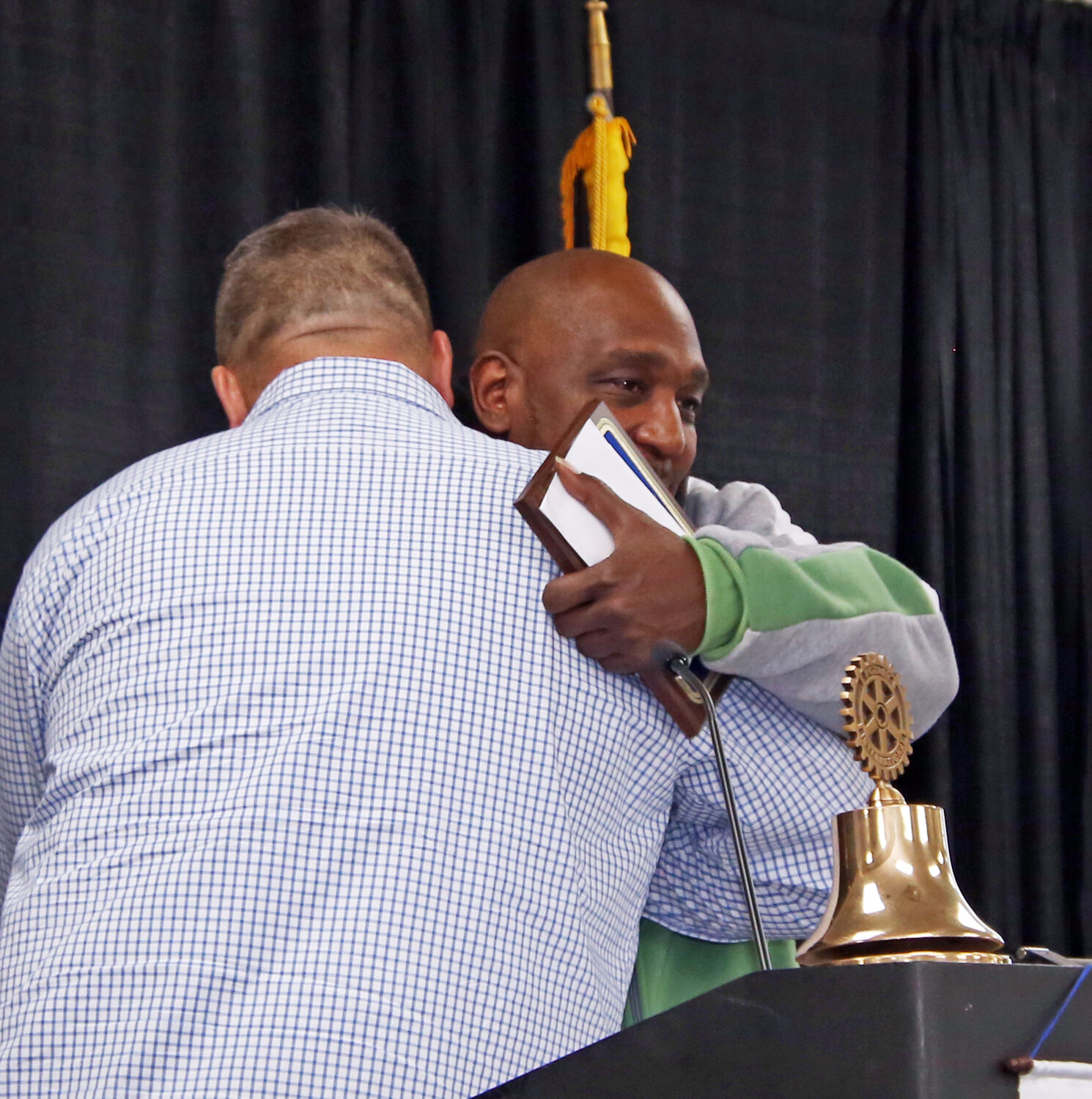 George McGinnity, of Beyond Your Walls, left, embraces Alfred Johns after Johns received a "Hero" award from the Rotary Club of Wicomico County.