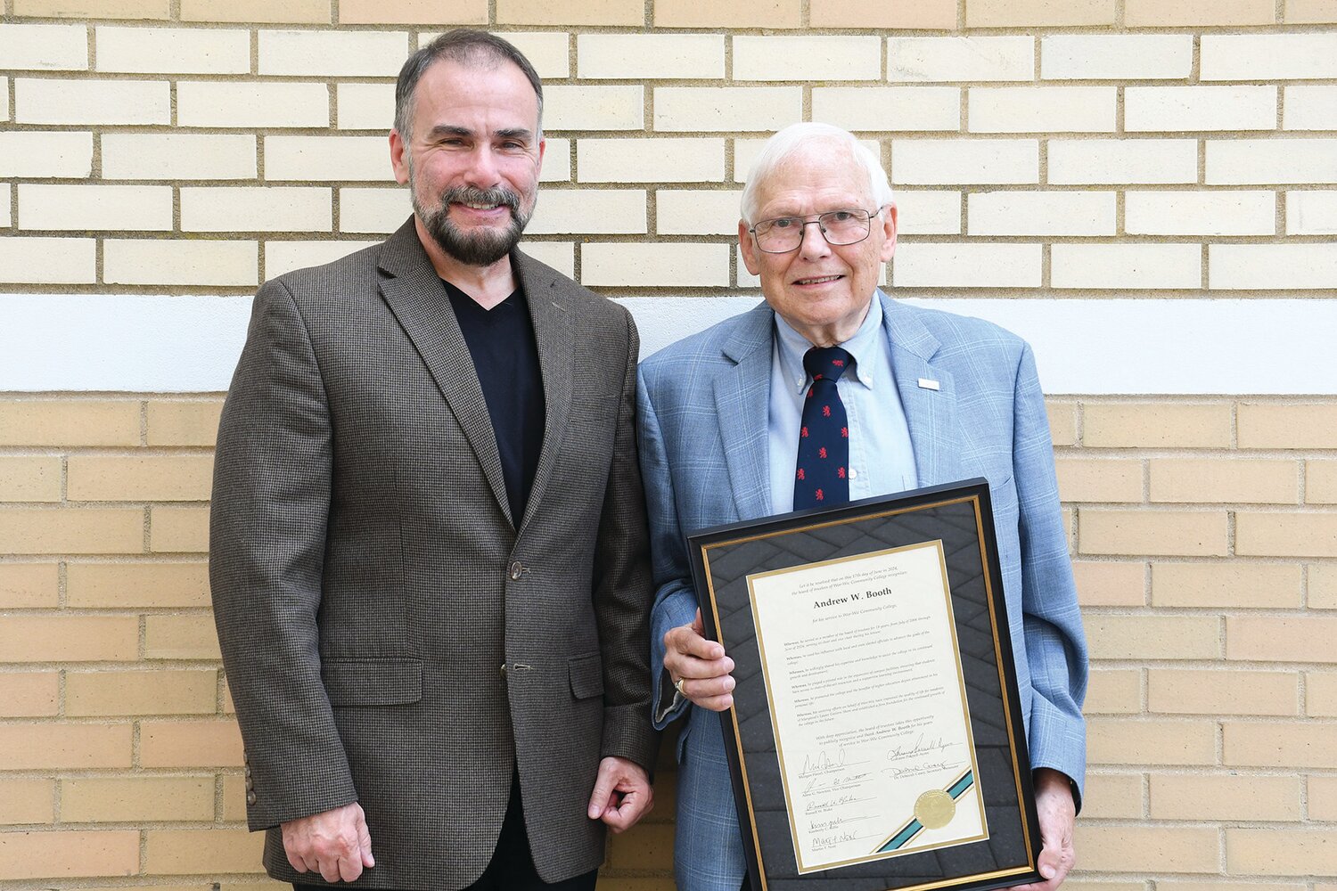 Morgan Hazel (left), chair of the Wor-Wic Community College board of trustees, presents retiring board member Andrew W. Booth with a proclamation in his honor.