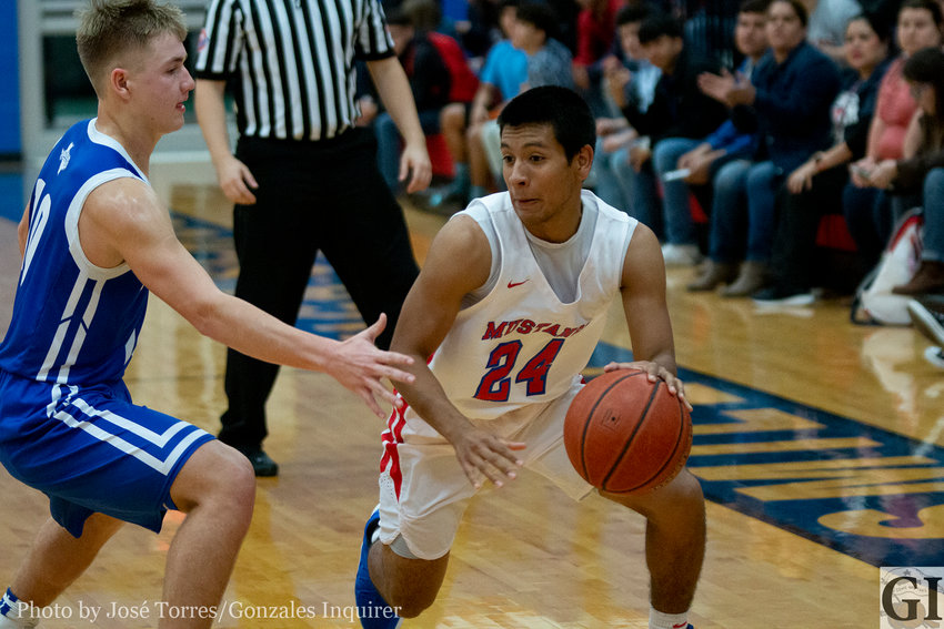 Jesus Vasquez (24) dribbles through a defender in Nixon-Smiley&rsquo;s 50-48 loss against Yoakum on Friday. Vasquez ended his night with nine points.