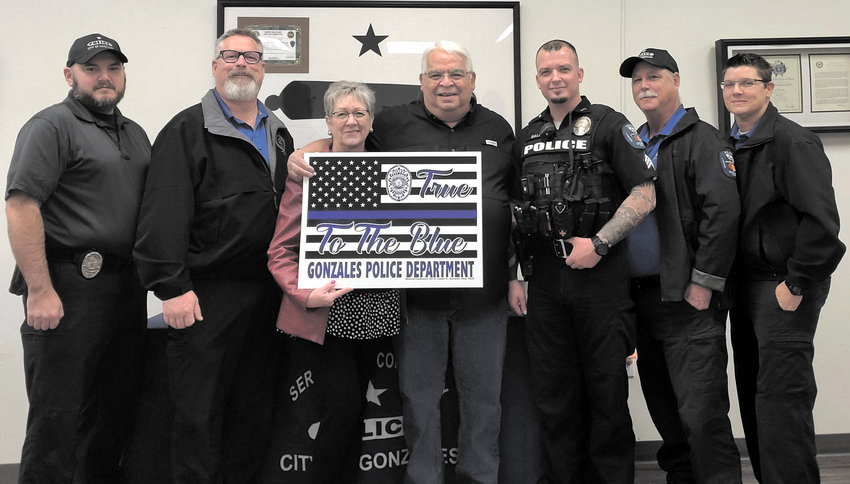 Personal Impressions owners Andy and Cindy Rodriguez give specially designed signs with &ldquo;True to the Blue&rdquo; to the Gonzales Police Department.