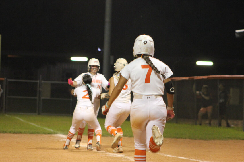 Lady Apaches Sarah Paddilla (7) runs towards first base with Ava Carrizales (2) and Sydney McCray (3) to celebrate Dixie Rae Lester&rsquo;s game winning RBI single in the bottom of the eighth.