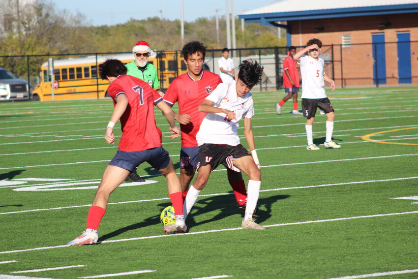 Apaches sophomore forward Maurico Cruz (10) battles two Veterans Memorial players for possession of the ball in the Friday, Dec. 20 scrimmage. Cruz scored the Apaches only goal in the match.
