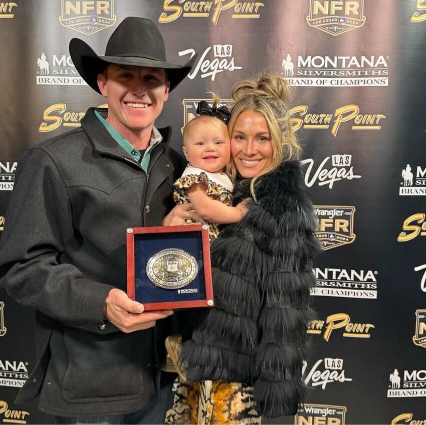 Marty Yates tied for first in the eighth round of the tie-down roping event at the 2024 Wrangler National Finals Rodeo in Las Vegas. He is pictured here with wife Loni Kay and daughter Miley Grace holding the buckle he received for winning the round.