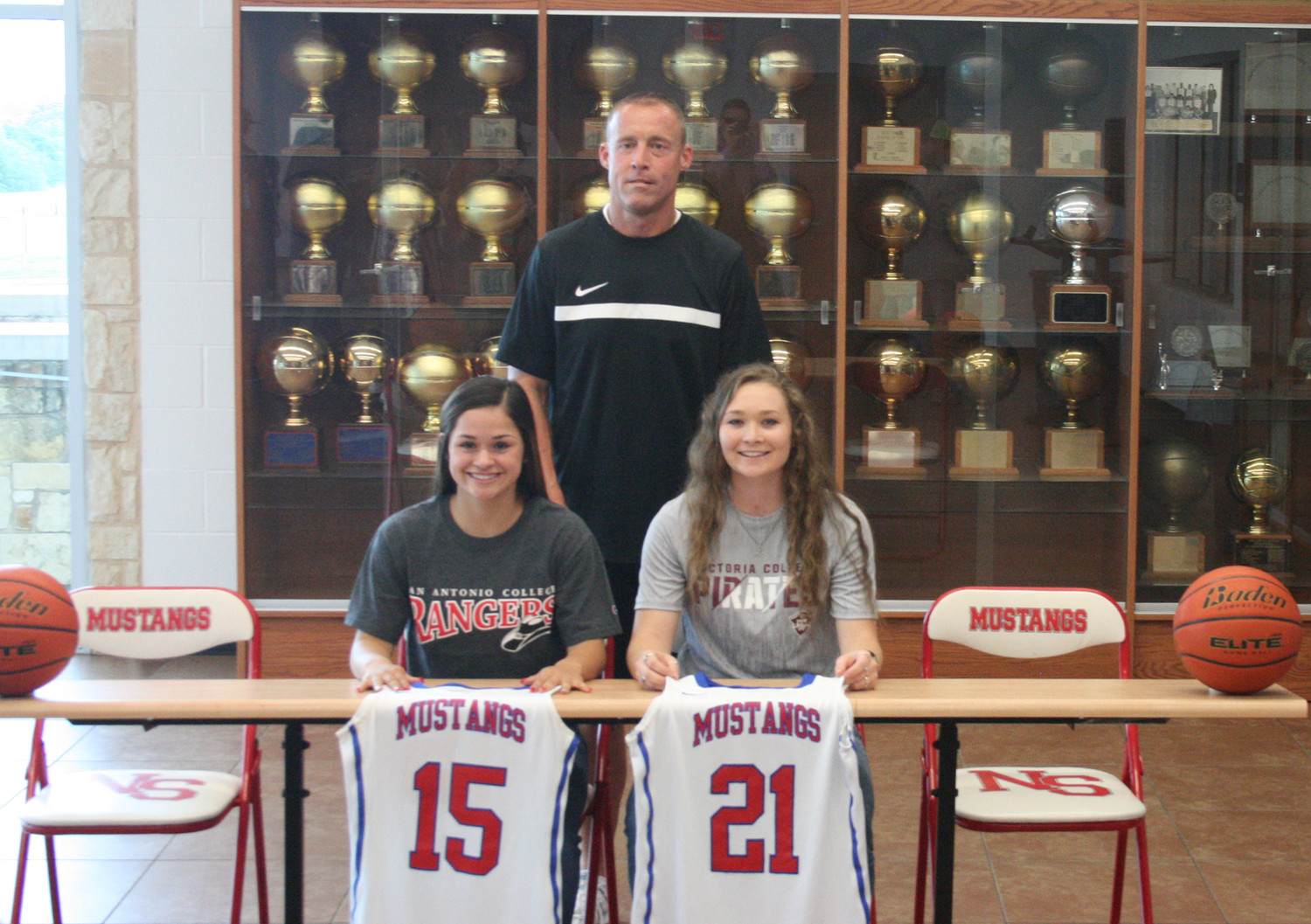 NIXON-SMILEY:
Head coach Scott Jones stands behind athletes Celeste Arriaga (left) and Lexi Trammell (right) who signed their letter of intents to play college basketball. Arriaga signed with San Antonio College while Trammell inked with Victoria College.