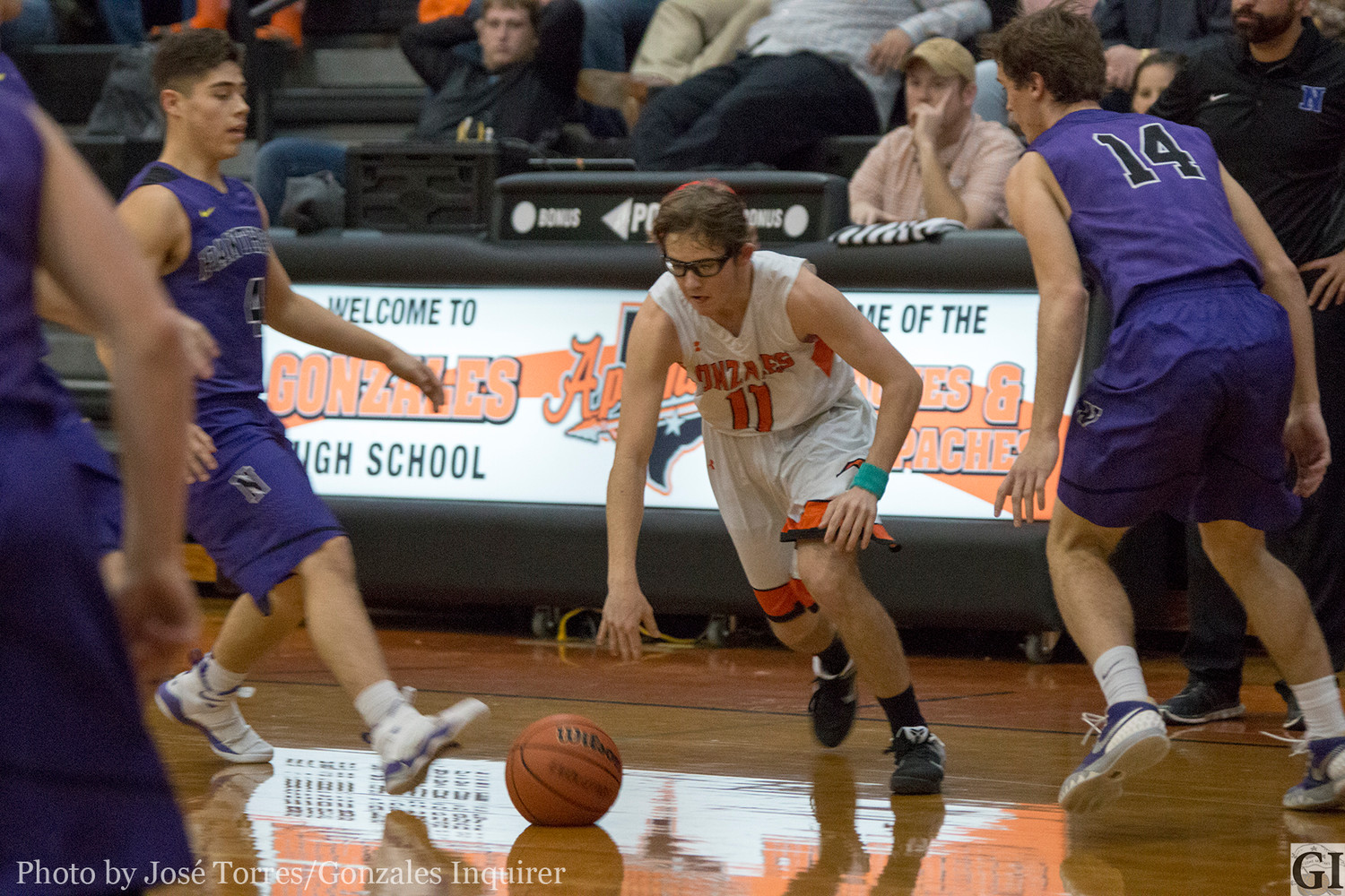 Mason Richter (11) dribbles through defenders in Gonzales’ 66-50 loss to Navarro last Friday. Richter ended the night with a team-leading 12 points.