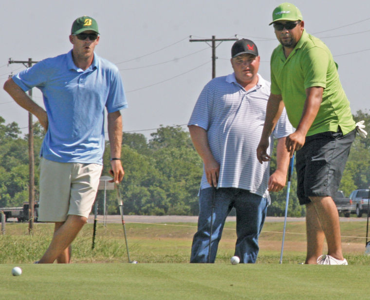 A group of golfers look on as the ball inched closer to the hole before it sunk in. PBR hosted the Rider Cup Saturday morning before the main event that evening.